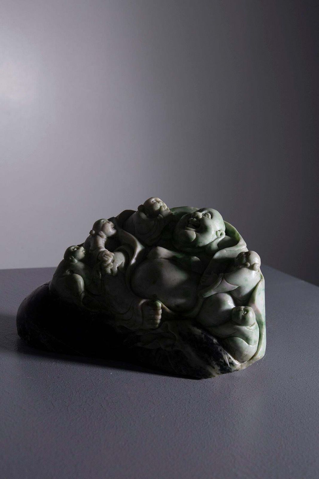 Sculpture Of Buddha Surrounded By Children In Jade Root photo vinterior