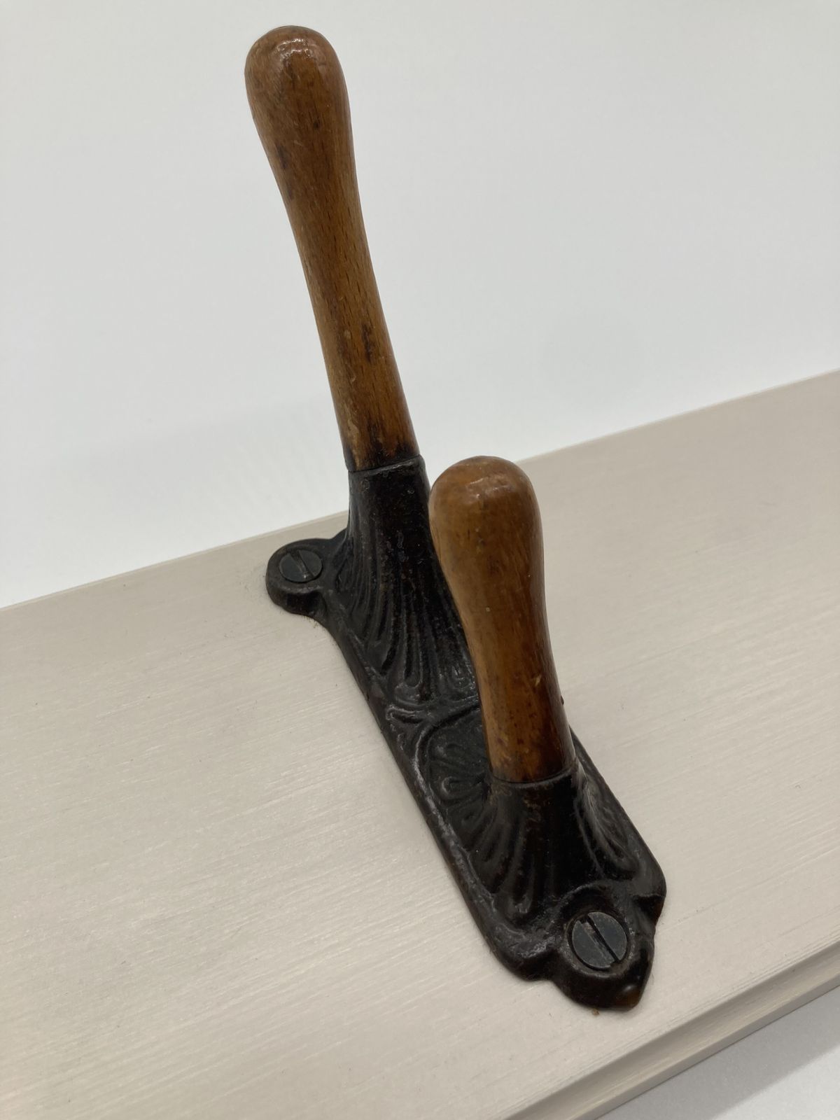 A Set Of Three Victorian Iron And Oak Coat Hooks Mounted On A Board photo furniture