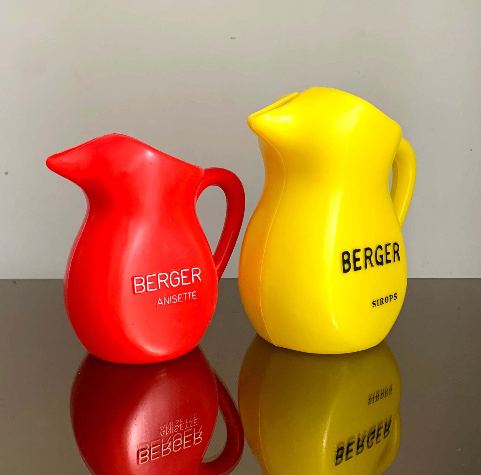 A Pair Of Vintage French Berger Anisette & Sirops Red & Yellow Plastic Jugs photo for sale