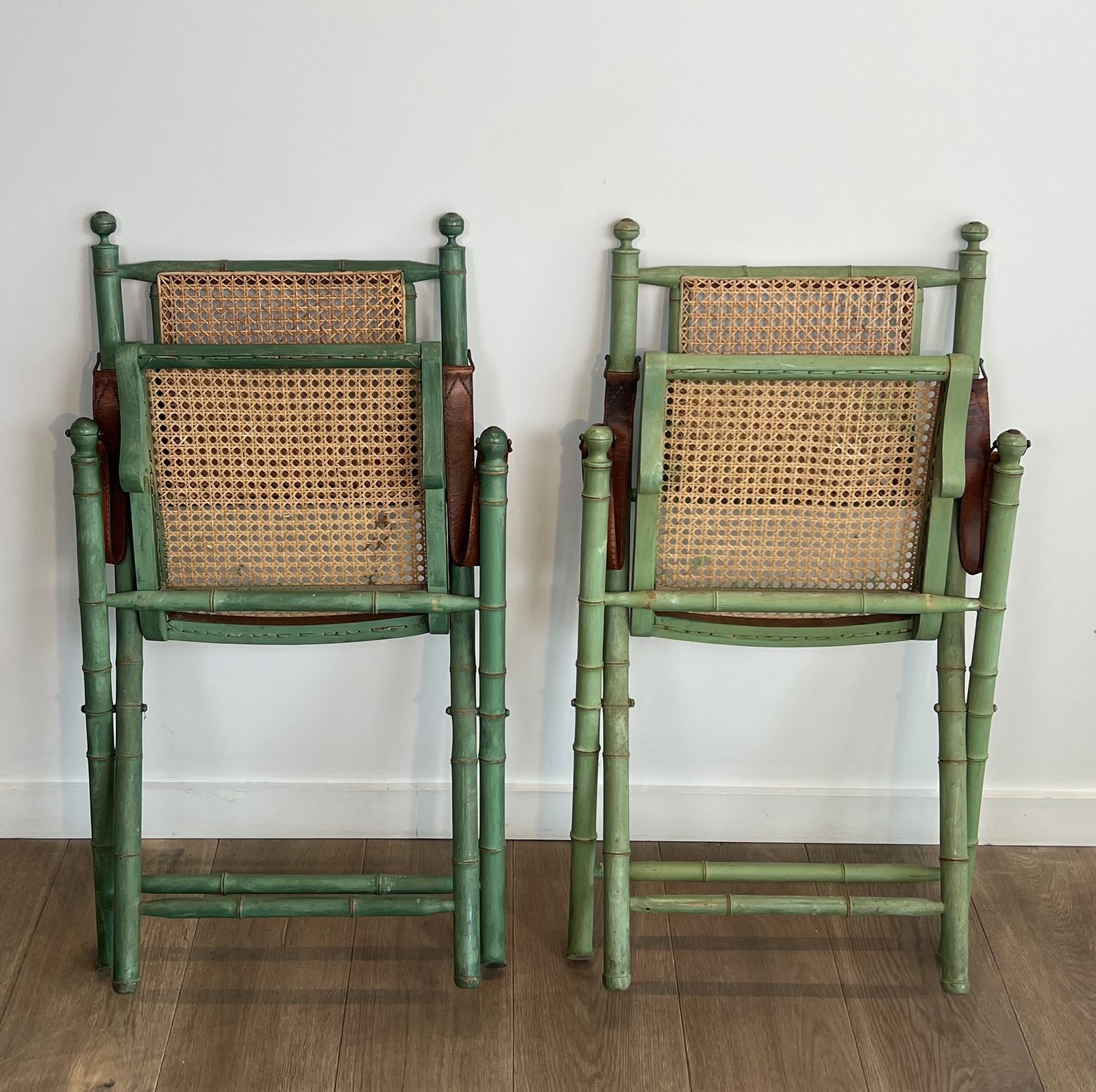 Pair Of Folding Safari Chairs In Weathered Faux Bamboo Style With Caned Backs And Seats And Leather Armrests photo for sale