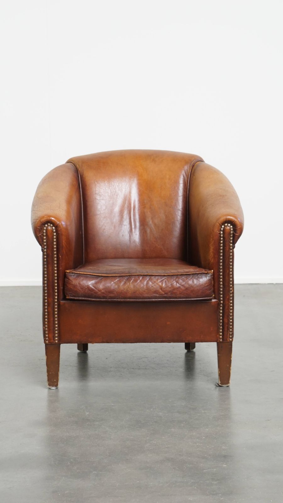 Stevige, Tijdloze Clubfauteuil In Cognackleurig Schapenleer Met Een Uitgesproken Vintage Uitstraling photo furniture