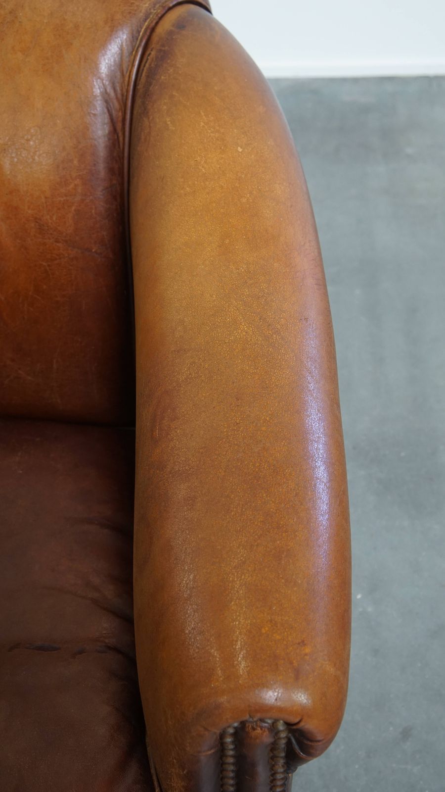 Stevige, Tijdloze Clubfauteuil In Cognackleurig Schapenleer Met Een Uitgesproken Vintage Uitstraling photo vintage