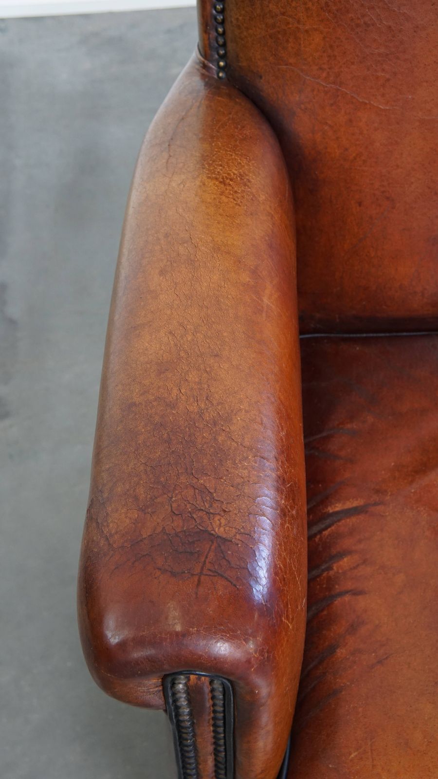 Stylish Sheepskin Designer Armchair In A Warm Cognac Color With A Finish Of Black Piping And Decorative Studs photo buy