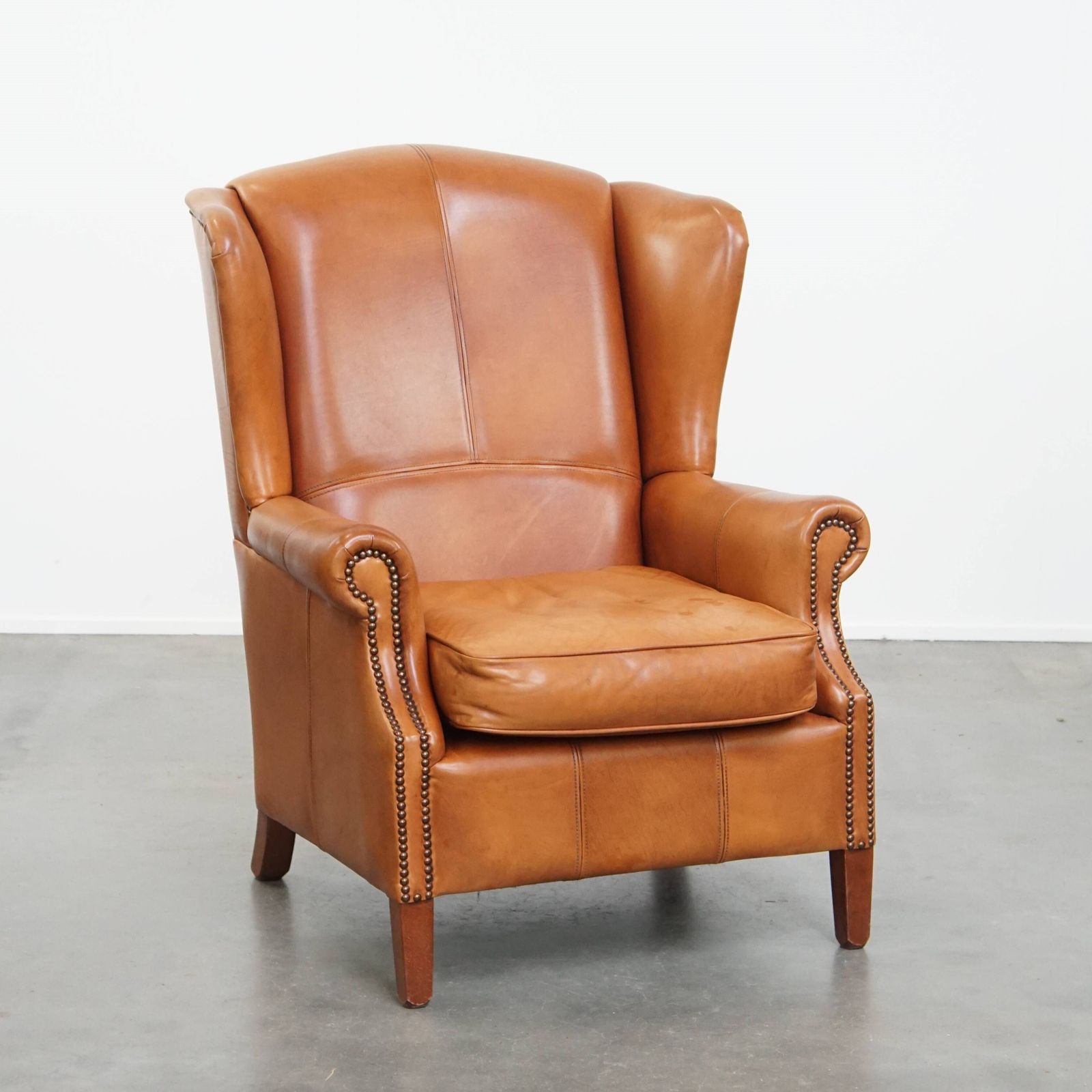 Classic And Unique Cowhide Wing Chair Finished With Decorative Nails And Beautiful Details