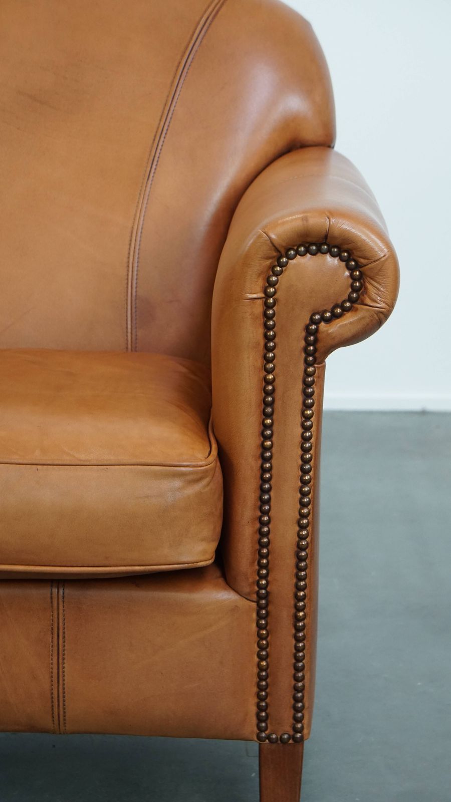 photo furniture Beautiful And Comfortable Cowhide Leather Armchair In A Warm Cognac Color Finished With Decorative Nails