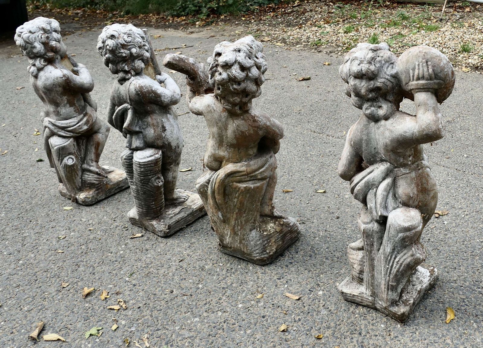 A Set Of 4 Weather Worn Cherub Statues With Instruments photo buy
