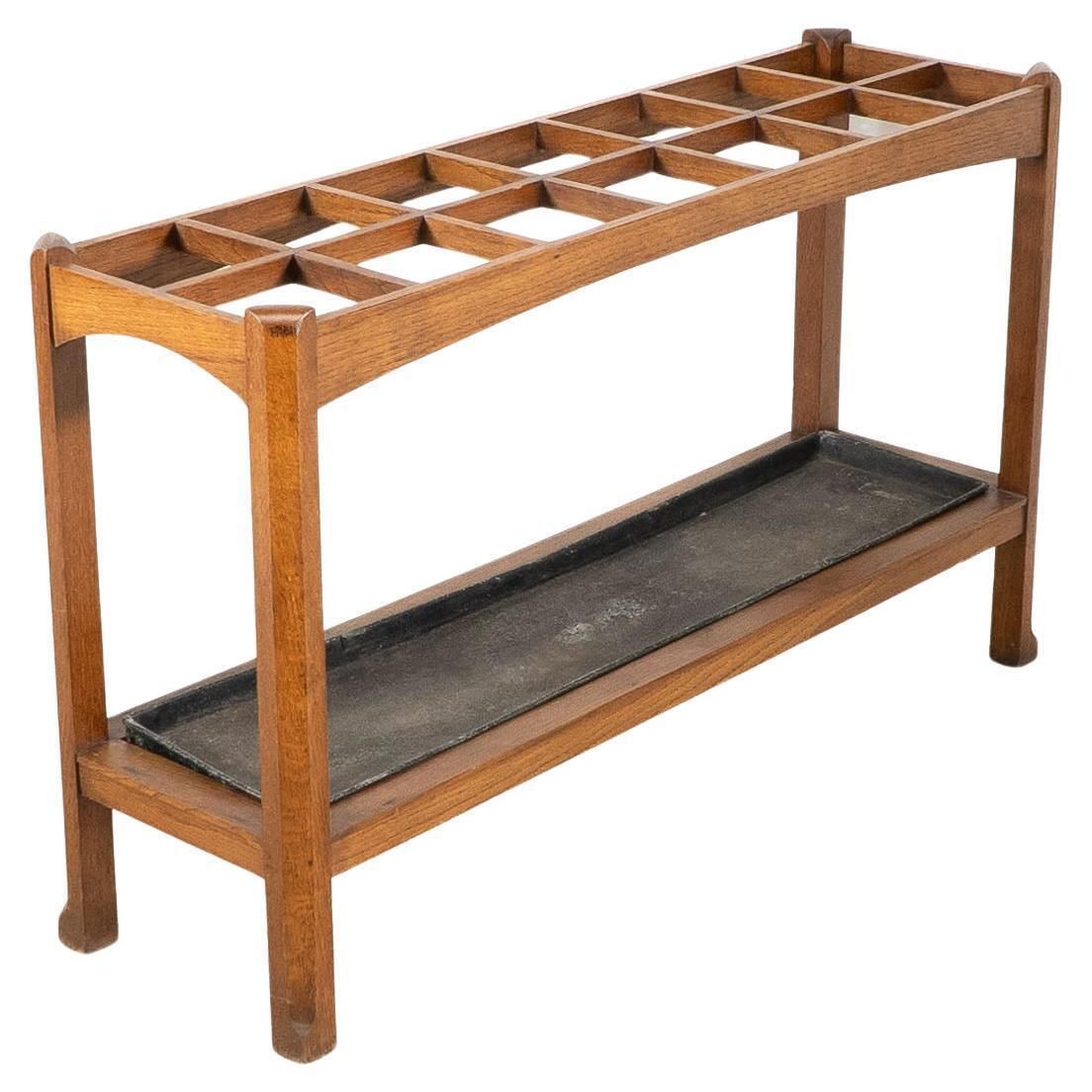 An Arts And Crafts Oak Stick And Umbrella Stand With Fourteen Sections