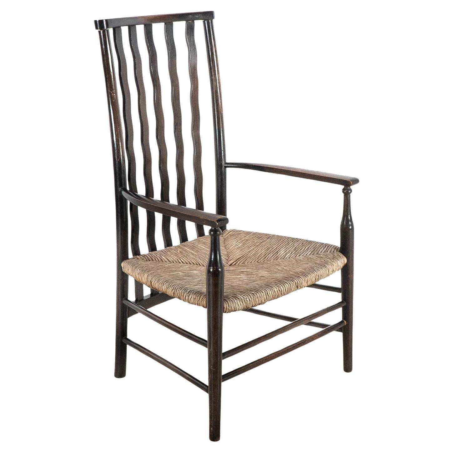 Liberty & Co. An Arts & Crafts Rush Seat Armchair With Wavy Shaped Back Slats