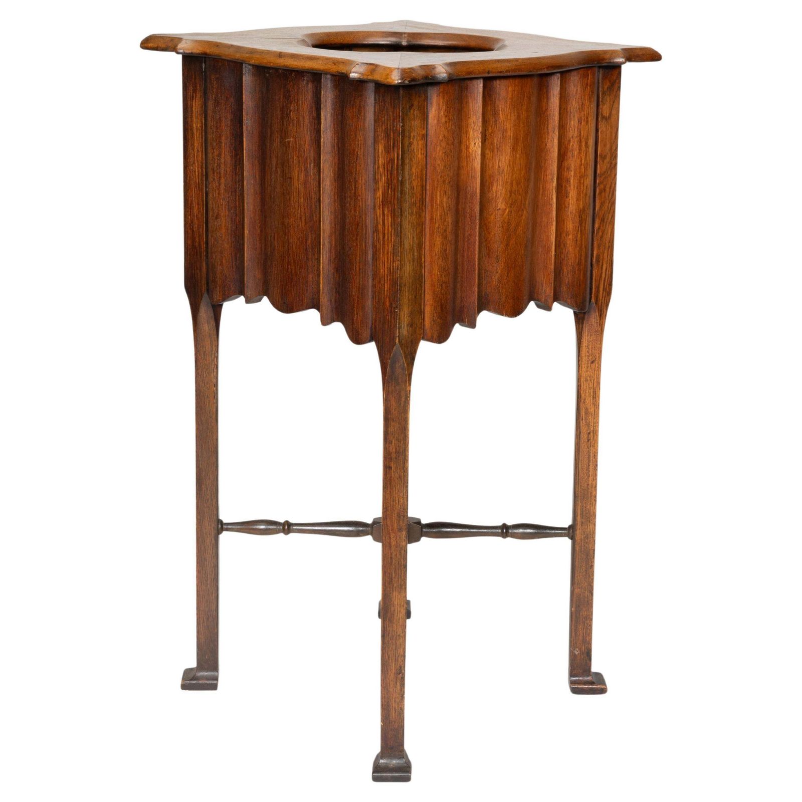 An Arts And Crafts Walnut Plant Stand With A Shaped Top And Ribbed Style Sides