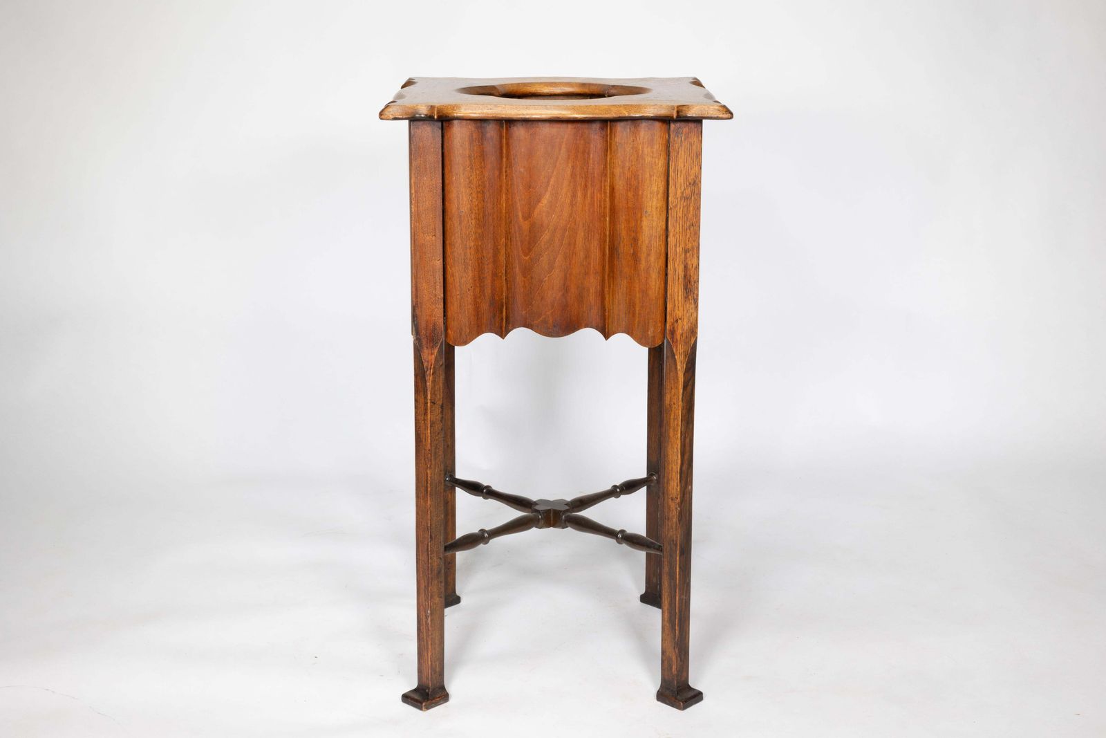 An Arts And Crafts Walnut Plant Stand With A Shaped Top And Ribbed Style Sides photo furniture