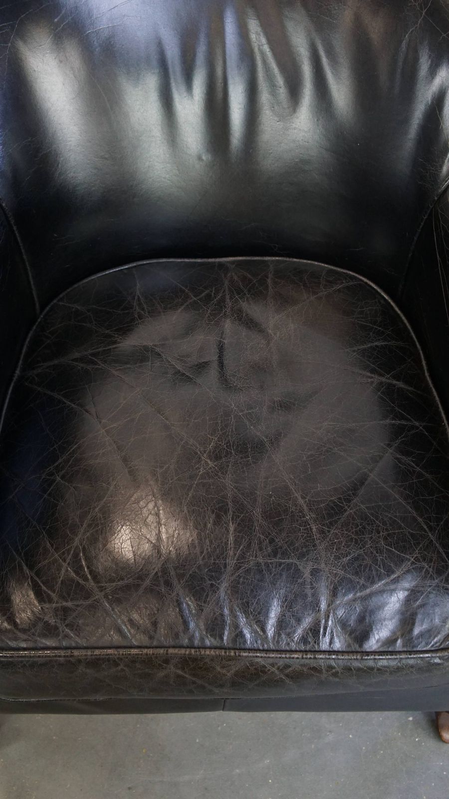 Stevige Zwarte Fauteuil Van Gegraneerd Koeienhuid Met Sierlijk Ontwerp photo vinterior
