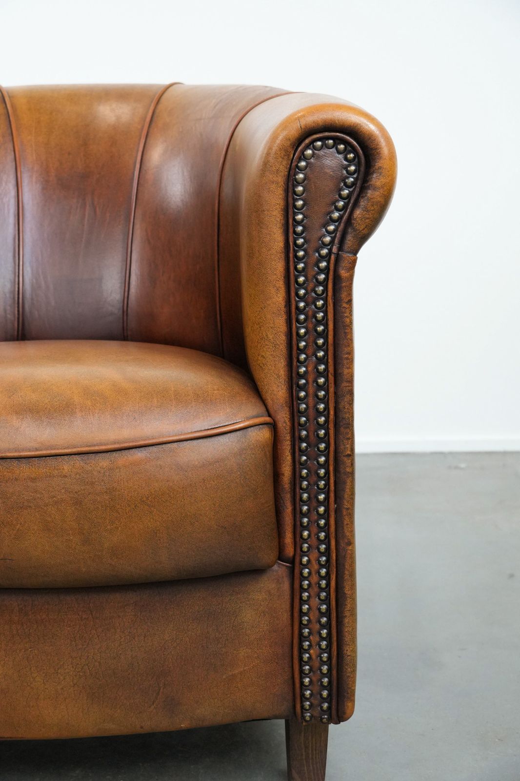 photo furniture Elegant Sheepskin Club Armchair With Beautiful Warm Colours, A Finish With Decorative Nails And Beautiful Stitching