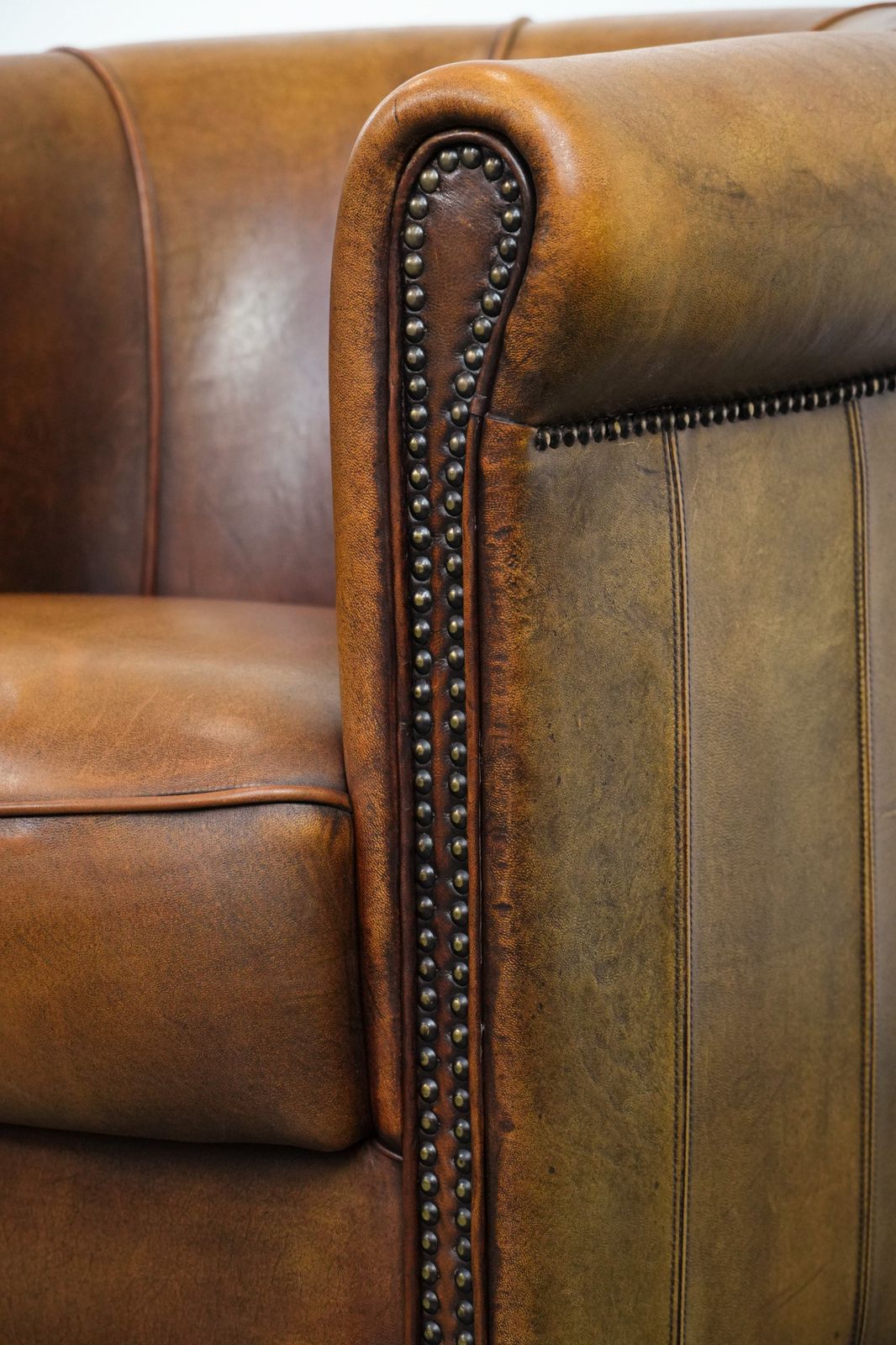 photo vinterior Elegant Sheepskin Club Armchair With Beautiful Warm Colours, A Finish With Decorative Nails And Beautiful Stitching