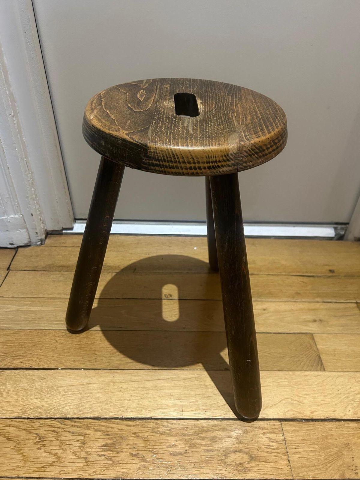 A Three Legged Wooden Stool With A Strong Brutalist photo for sale