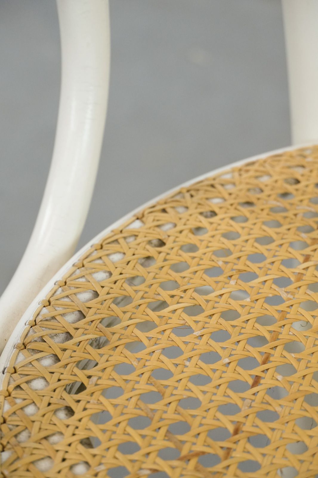 photo vintage Vintage White Bistro Chair With Armrests In Thonet Style With A Graceful Curved Wooden Frame, Webbing Seat And Backrest