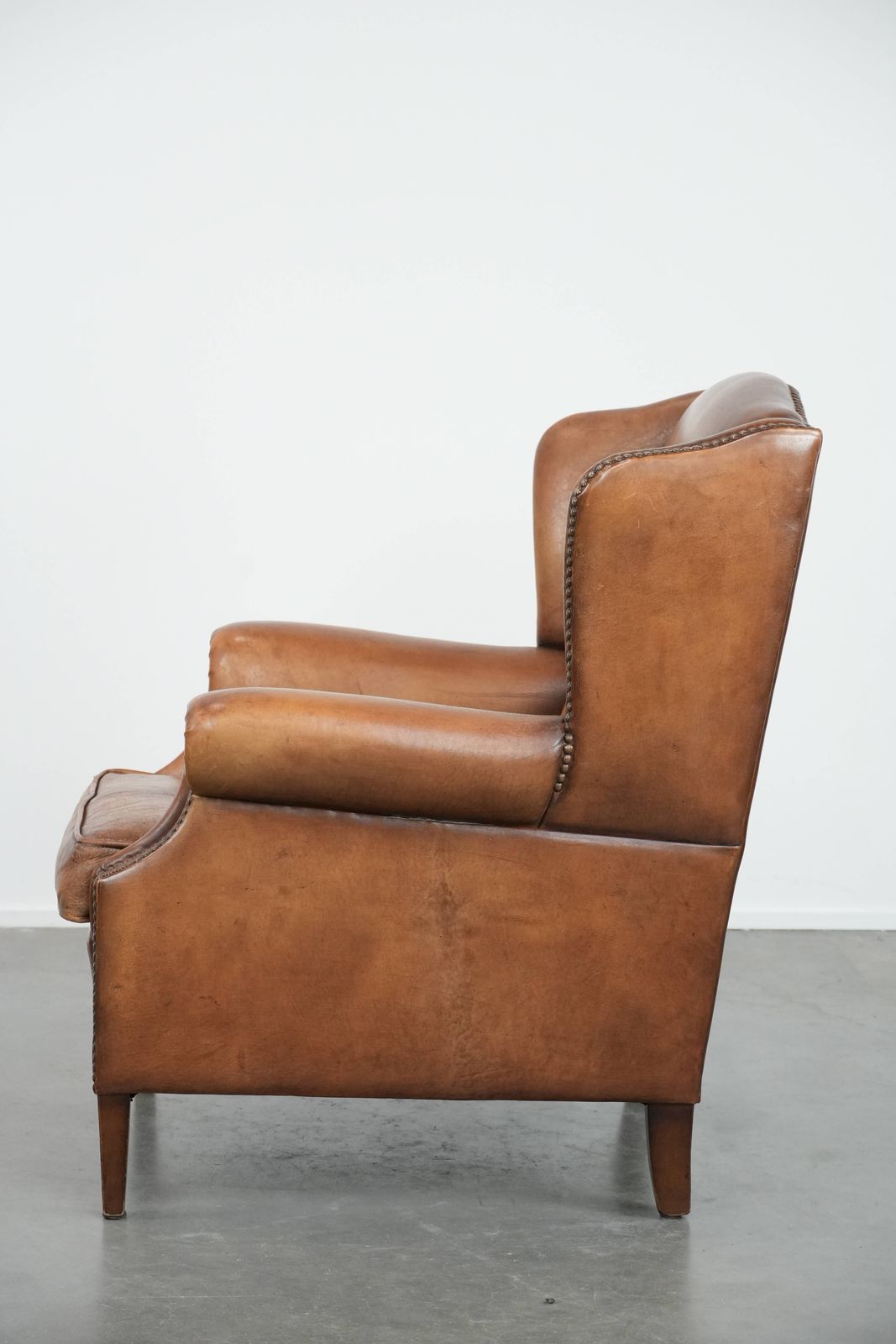 Charmante Schapenvacht Wingback Fauteuil In Warme Kleuren Met Decoratieve Sierspijkers photo 935.0