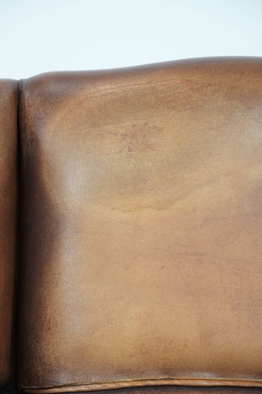 photo vintage Charming Sheepskin Wing Chair With Warm Colours Finished With Decorative Studs