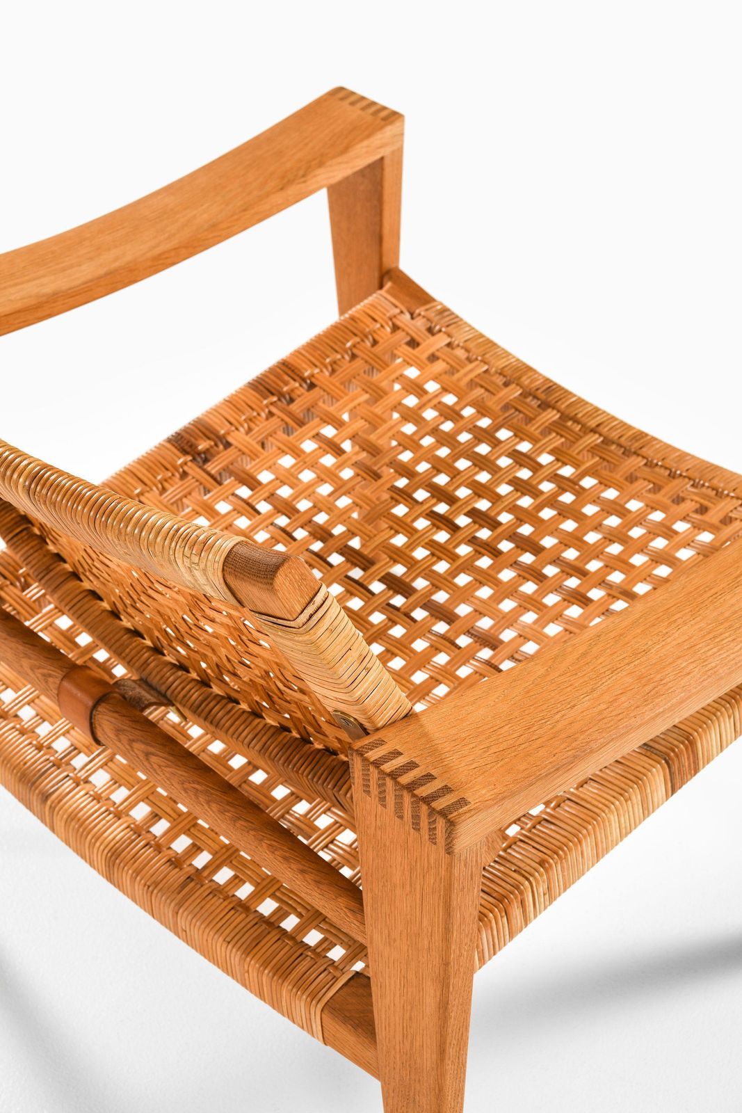 photo for sale Pair Of Easy Chairs In Oak, Woven Cane, Brass And Leather By Hans Wegner, 1959