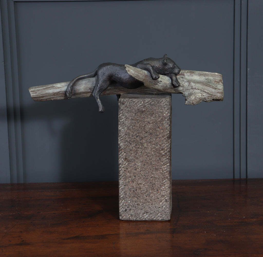 photo buy Bronze Sculpture Of A Resting Lioness On Cold Painted Log
