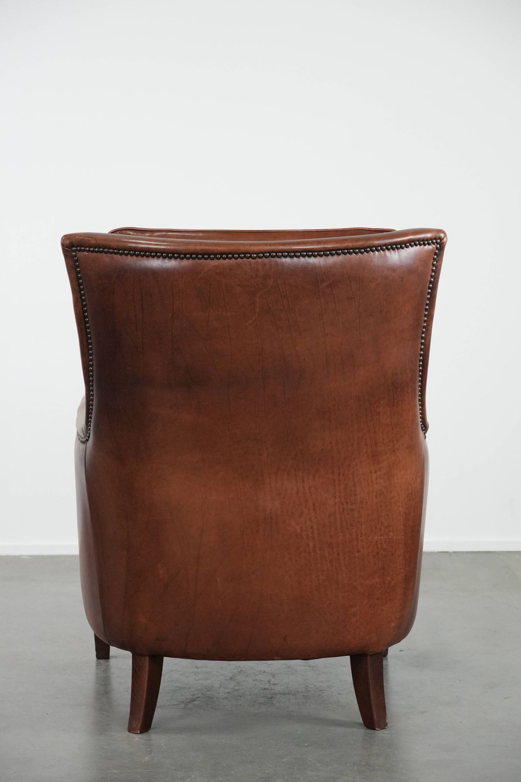 Comfortabele En Luxueuze Cognacbruine Rundleren Fauteuil Met Decoratieve Sierspijkers photo Meubels