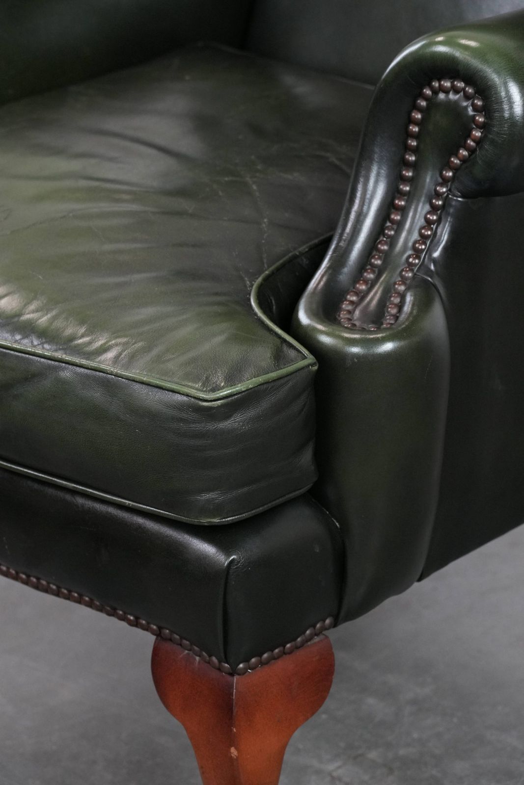 photo vintage Beautiful Smooth Classic Cowhide Chesterfield Wing Chair In A Stylish Dark Green Color