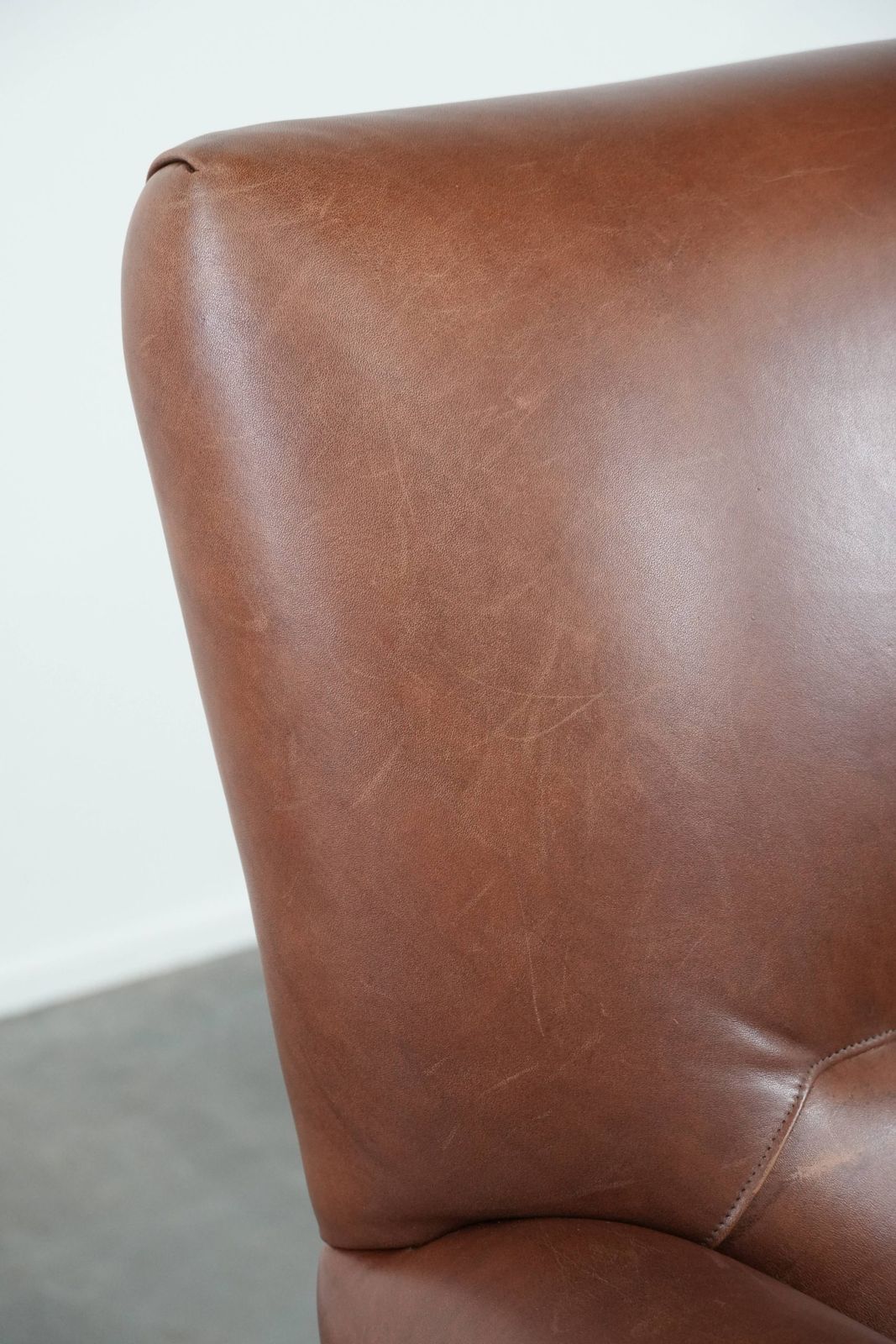 photo vintage Comfortabele Fauteuil Van Cognackleurig Koeienleer In Engelse Stijl