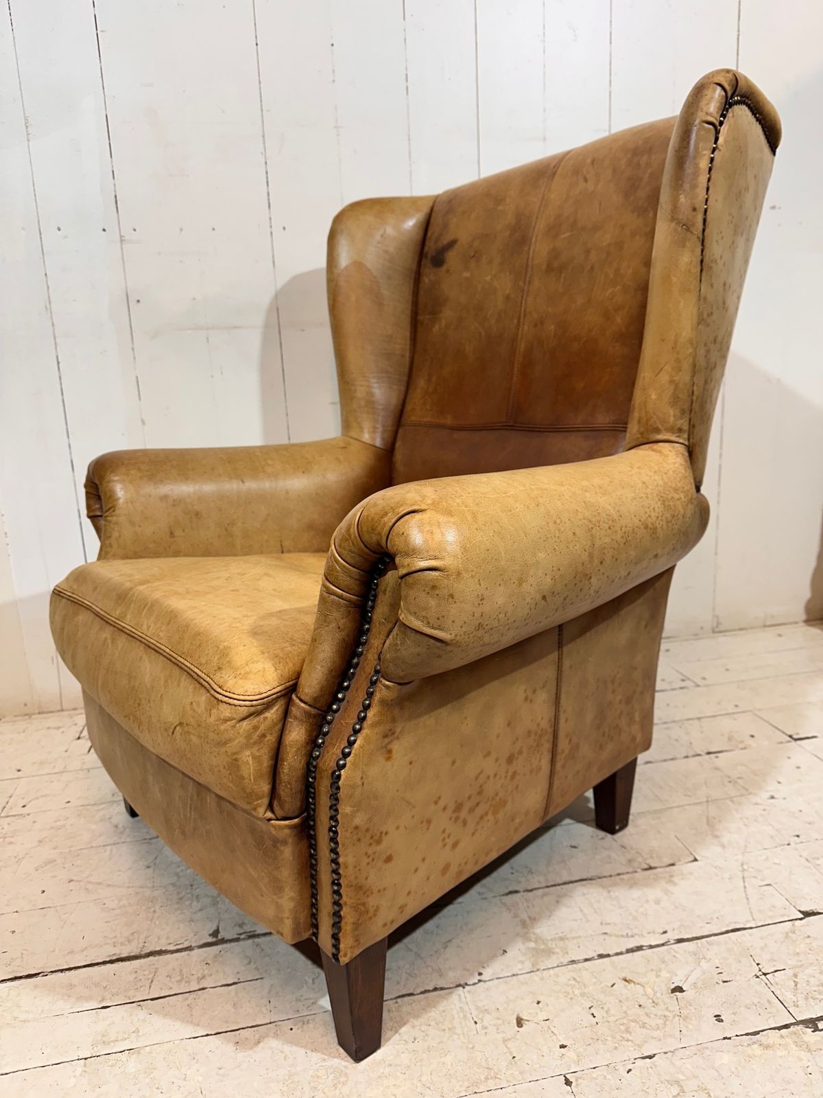 photo for sale Vintage Hotel Lounge Wingback Armchair In A Distressed Aniline Leather