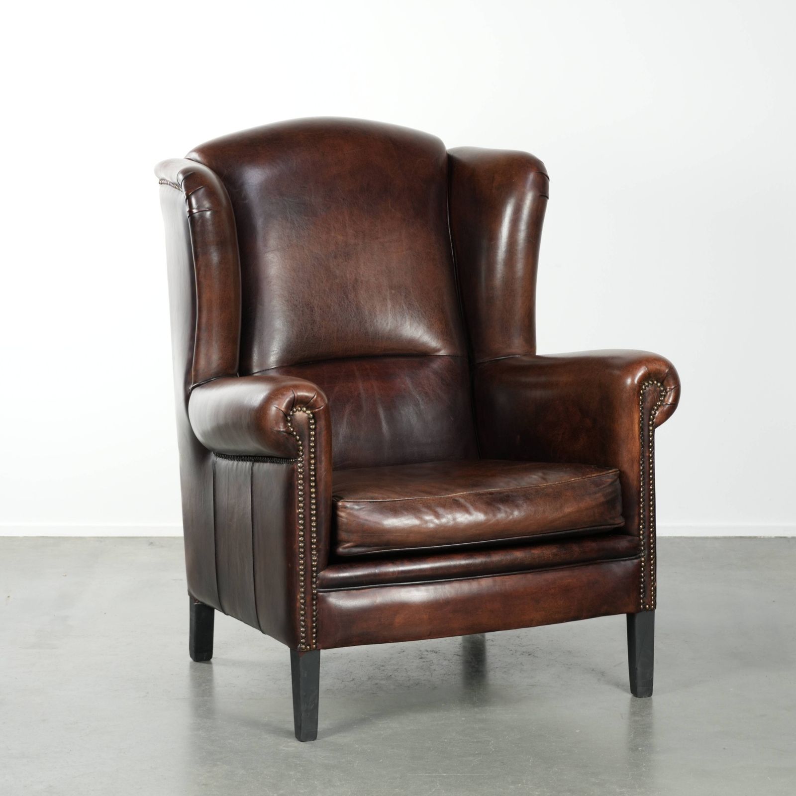 Beautiful Large And Comfortable Sheepskin Wing Armchair With Lovely Deep And Warm Colors And A Finish With Decorative Nails.