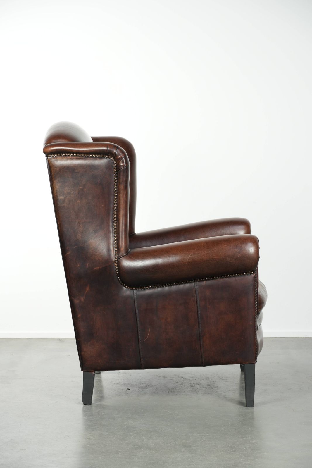 Beautiful Large And Comfortable Sheepskin Wing Armchair With Lovely Deep And Warm Colors And A Finish With Decorative Nails. photo for sale