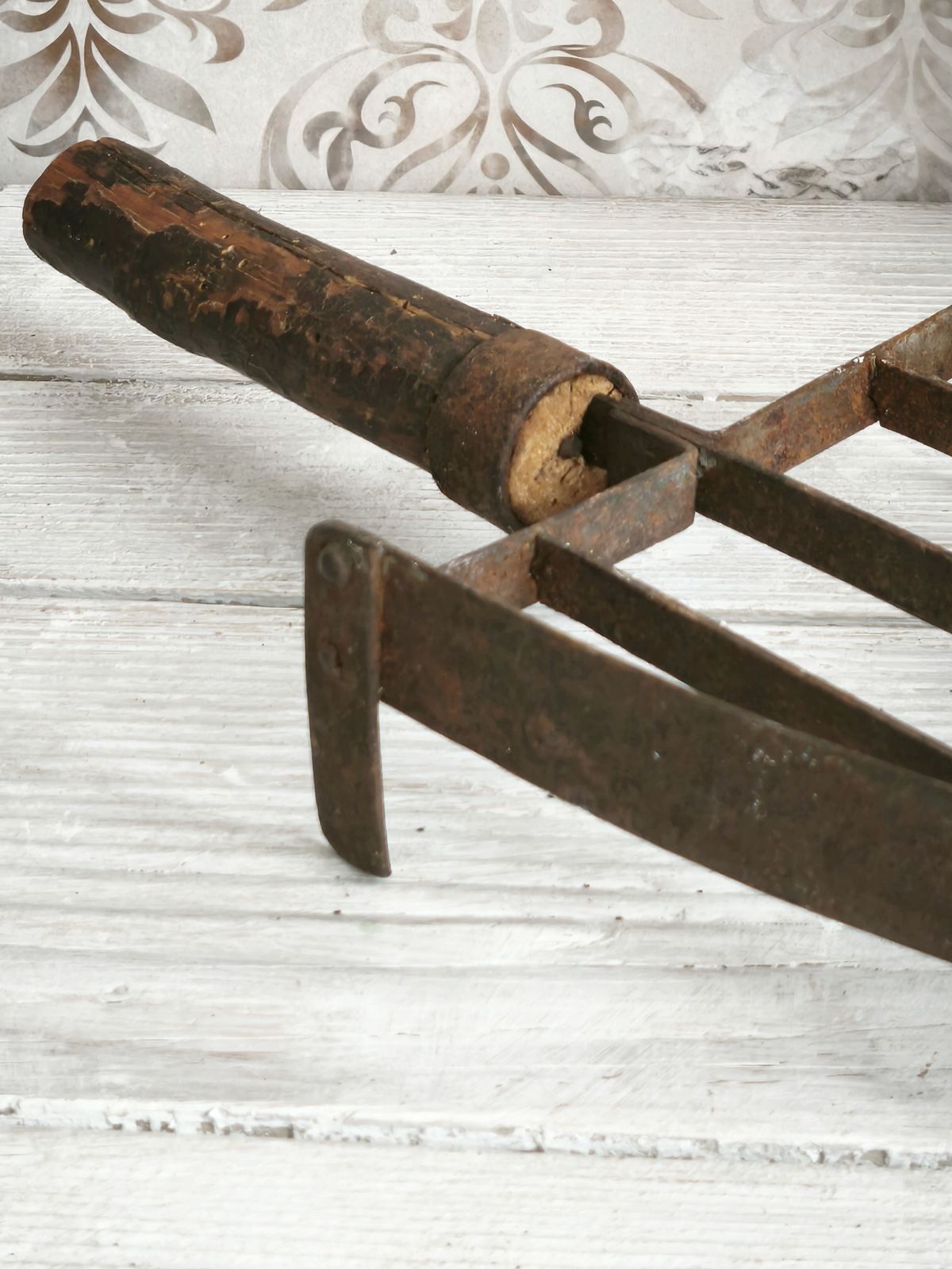 Antieke handgesmede ijzeren treeft met houten handvat photo for sale