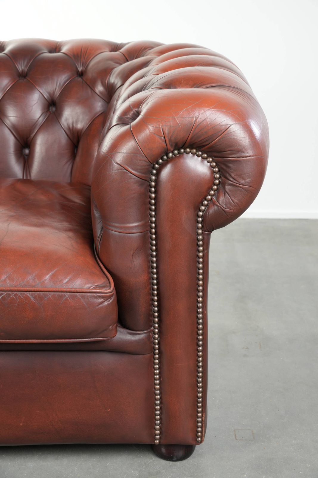 photo furniture Beautiful Red/Brown Cowhide Chesterfield Armchair In A Classic English Style With A Stunning Appearance.