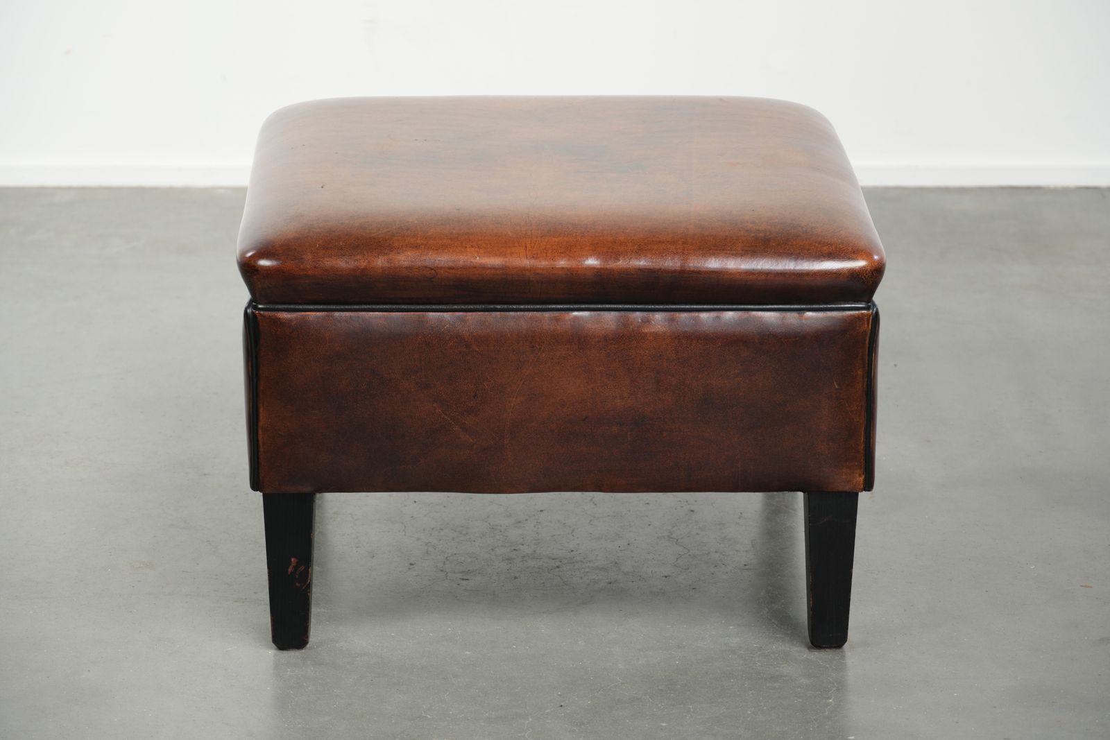 Grote Donkerbruine Vierkante Ottoman Van Schapenvacht Met Zwart Biesje photo furniture