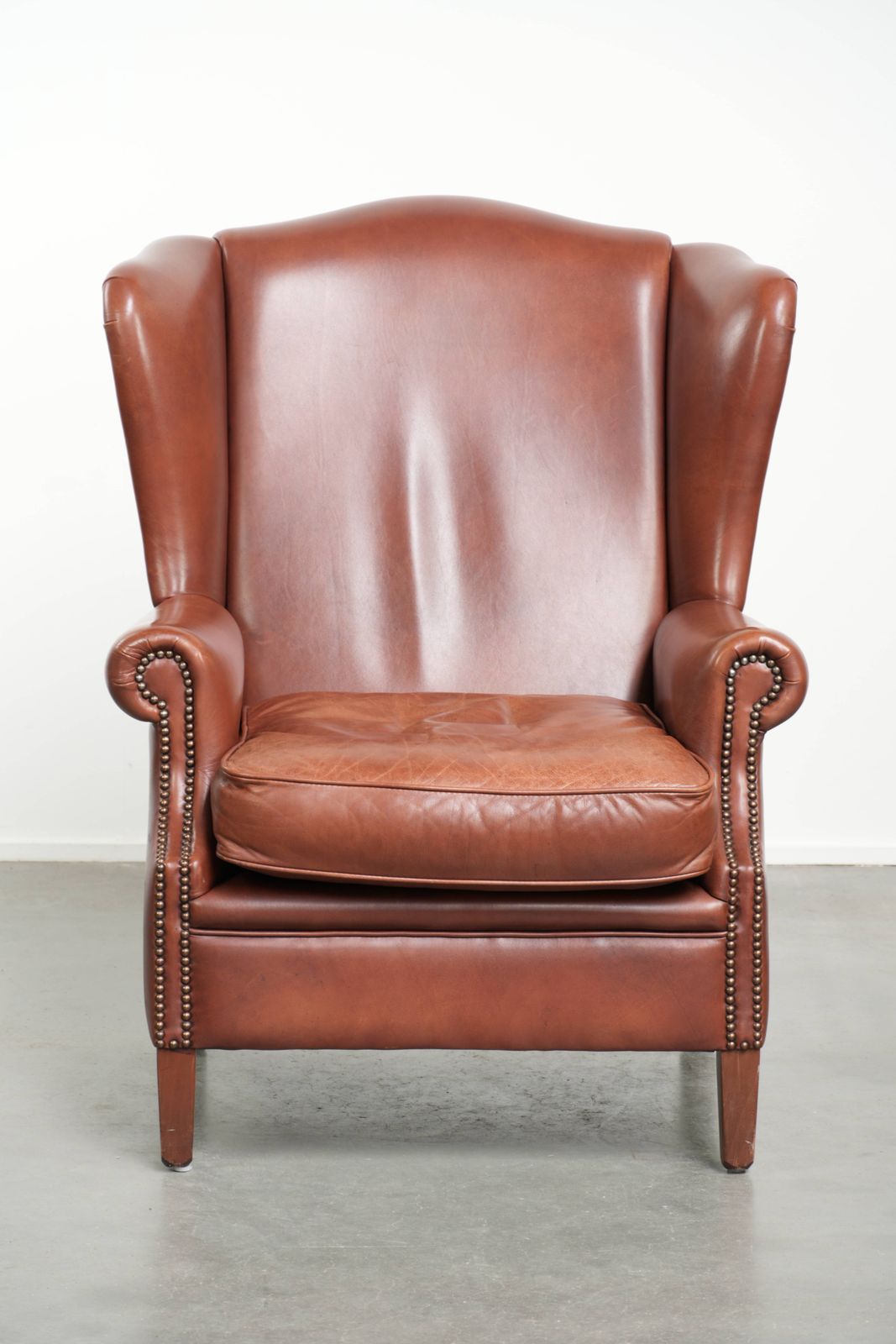 Comfortable Cognac Colored Cowhide Leather Wing Armchair In English Style With A Warm Appearance photo furniture