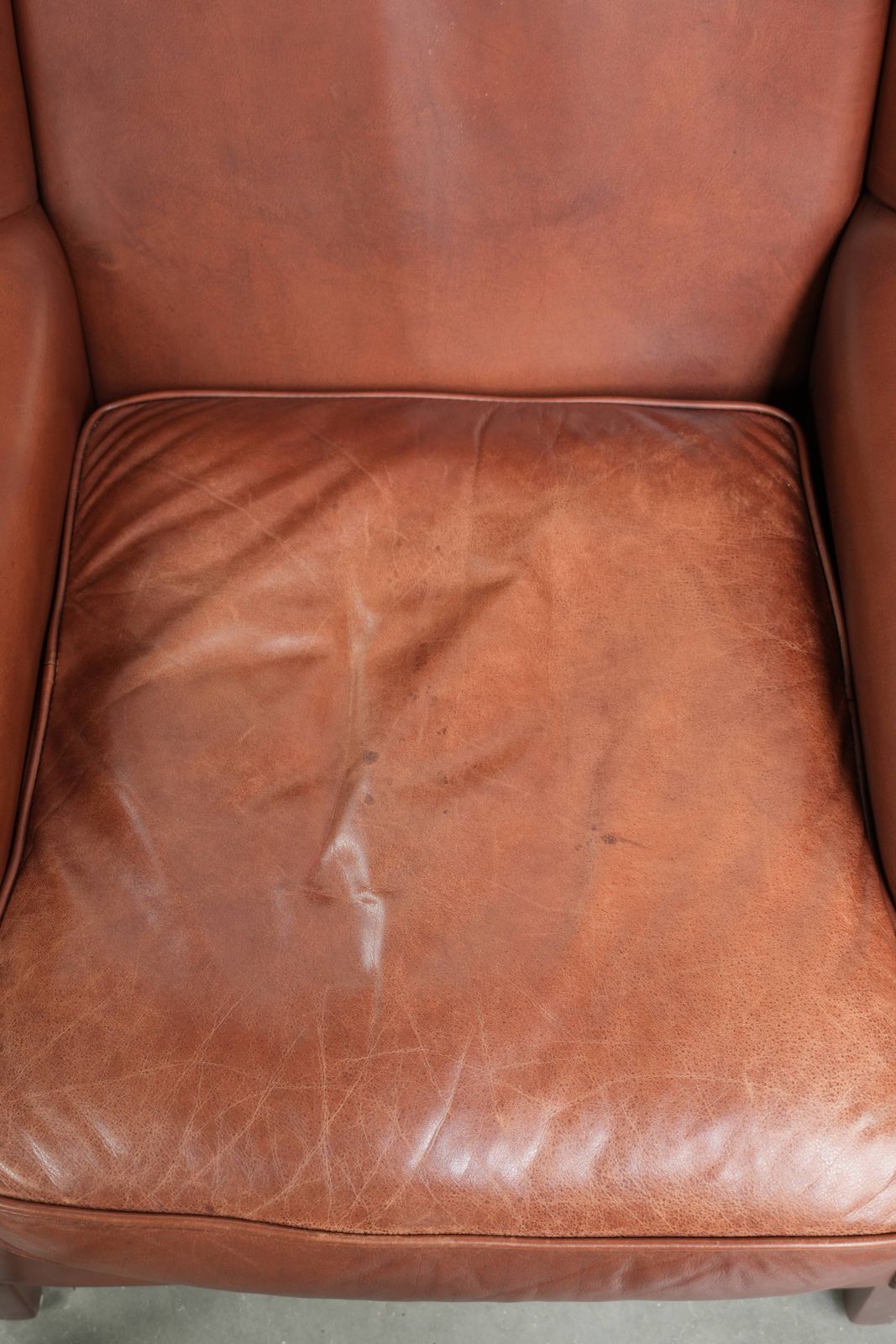 Comfortable Cognac Colored Cowhide Leather Wing Armchair In English Style With A Warm Appearance photo vinterior