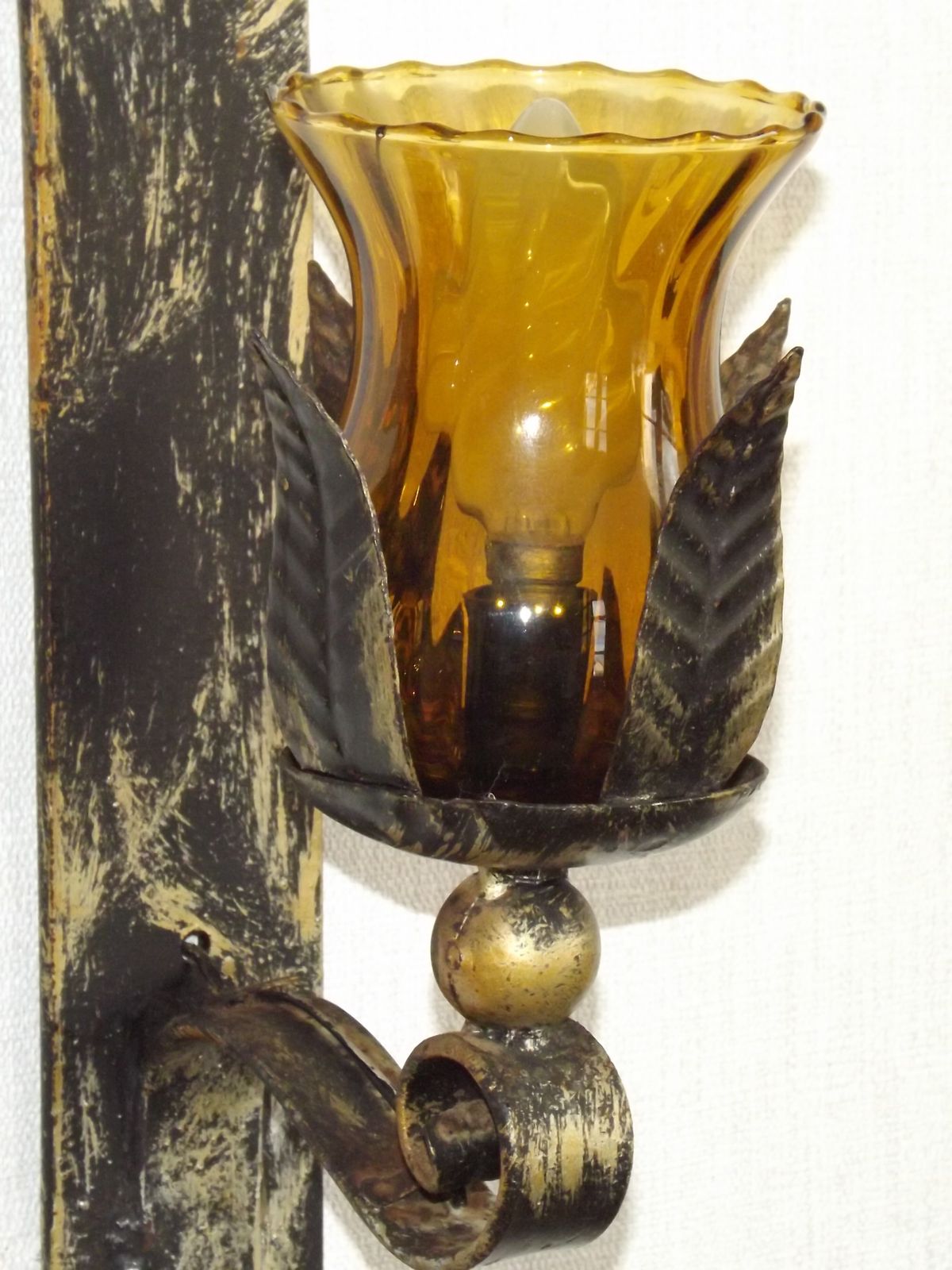 Paar handgesmede smeedijzeren wandlampen in middeleeuwse stijl met amberkleurige glazen kappen photo vintage
