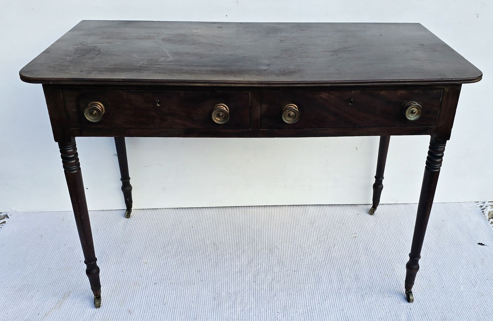 An Antique Regency Mahogany Writing Desk On Castors. photo furniture