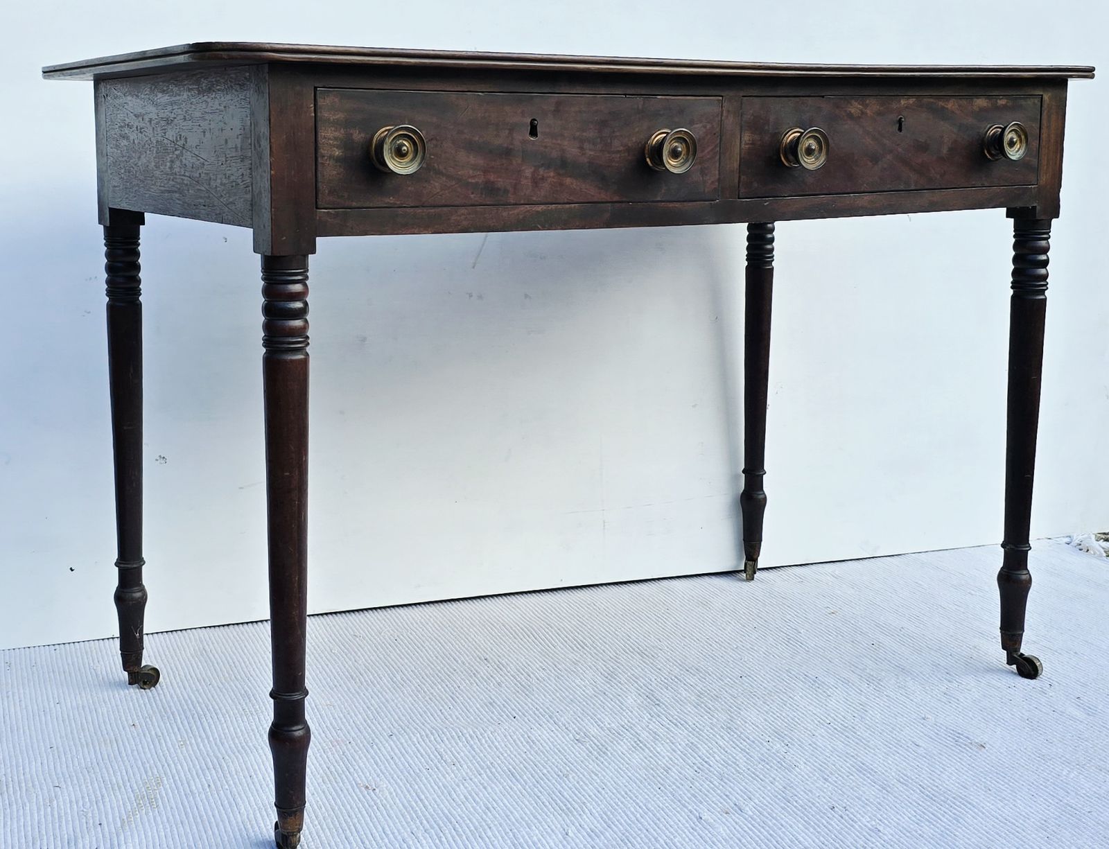 An Antique Regency Mahogany Writing Desk On Castors. photo Furniture