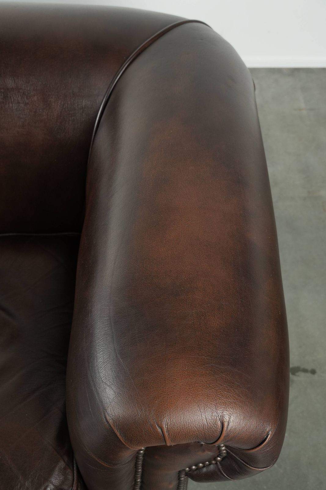 photo furniture Luxueuze bruine gladde rundleren Chesterfield-bank met een tijdloze Engelse uitstraling.