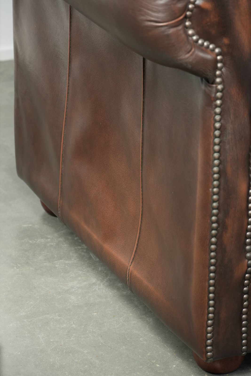 photo vinterior Luxueuze bruine gladde rundleren Chesterfield-bank met een tijdloze Engelse uitstraling.