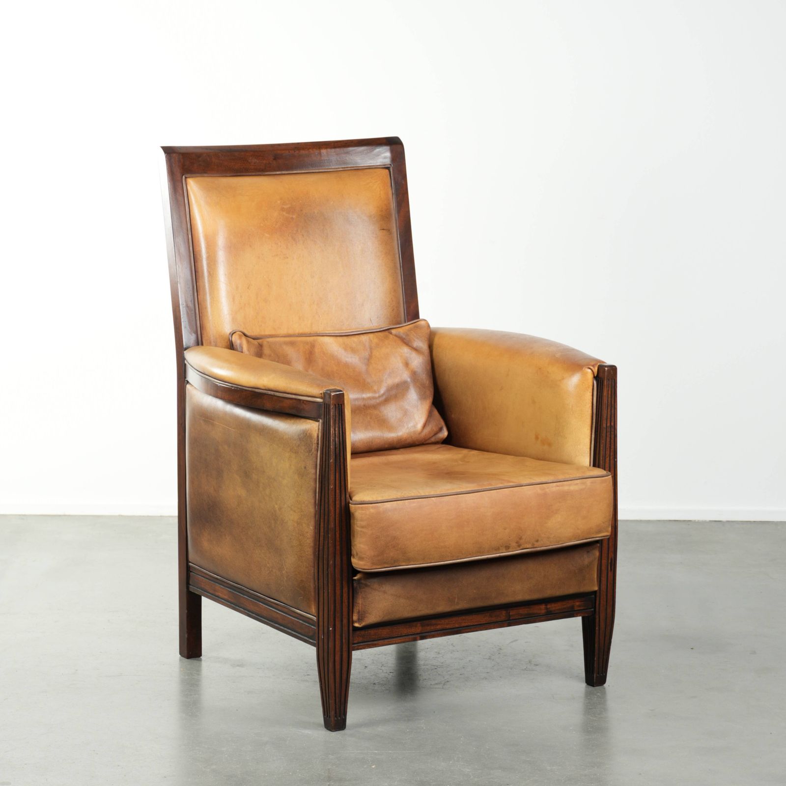 Comfortabele Cognackleurige Art Deco Fauteuil Van Schapenleer Gecombineerd Met Hout, Met Hoge Rug.