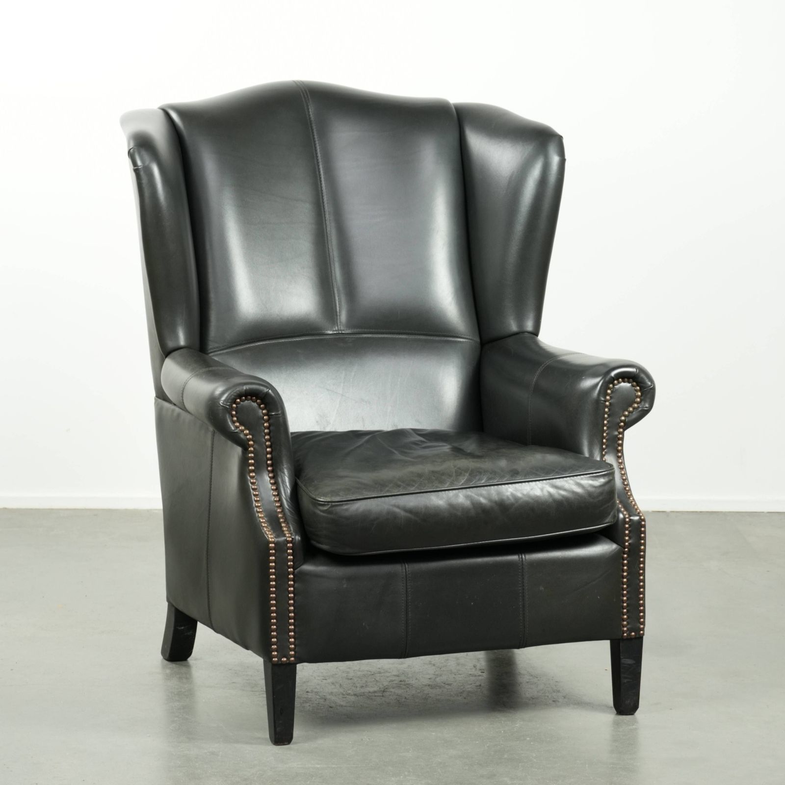 Black Cowhide Wing Armchair In A Classic English Style, Finished With Decorative Nails.