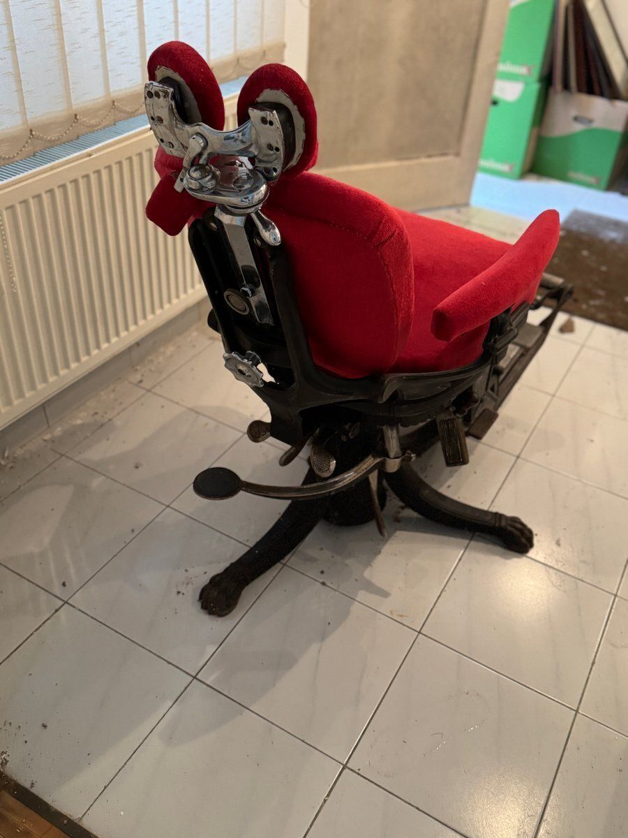 Kappersstoel met rode bekleding en verstelbare voetensteun photo Meubels