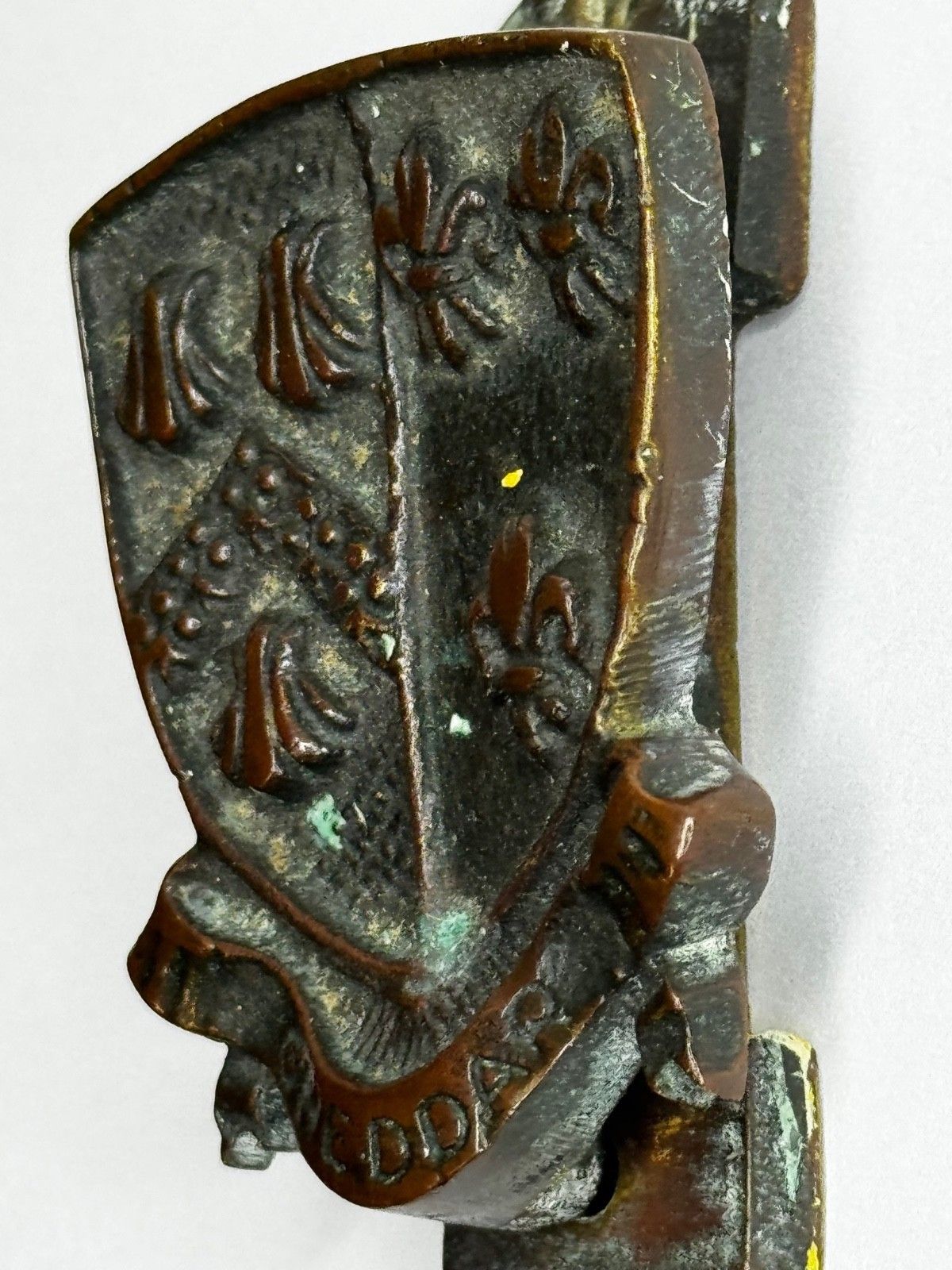 photo furniture Begin 20e eeuw bronzen deurklopper uit Cheddar, heraldisch wapenschild met Fleur De Lys, ca. 1925