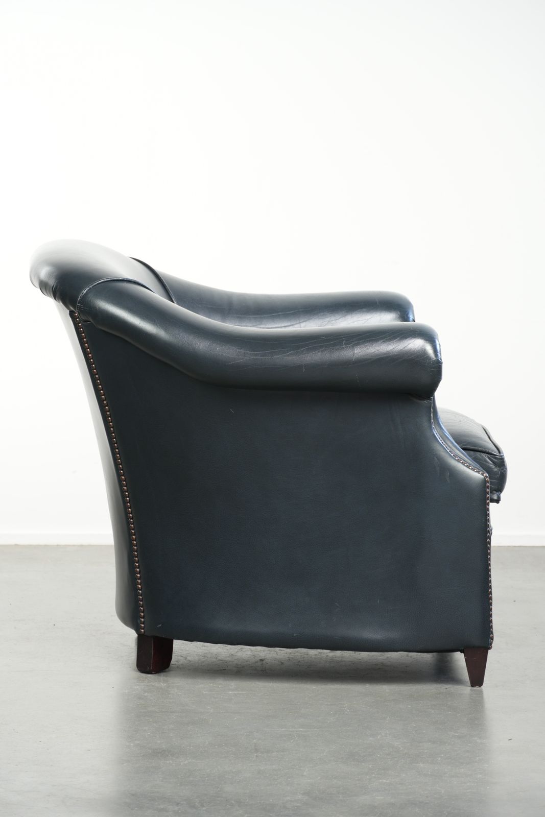 Mooie en comfortabele donkerblauwe lederen club fauteuil met een uniek en tijdloos design photo for sale