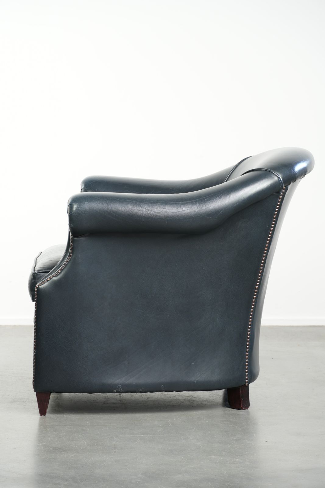 Mooie en comfortabele donkerblauwe lederen club fauteuil met een uniek en tijdloos design photo 860.0