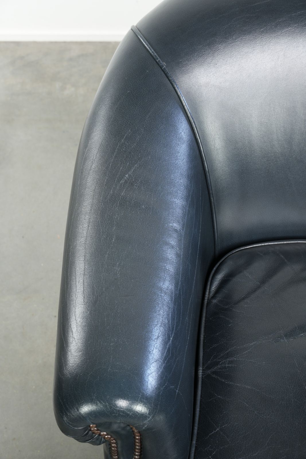 Donkerblauwe clubfauteuil van koeienleer met tijdloos design photo buy