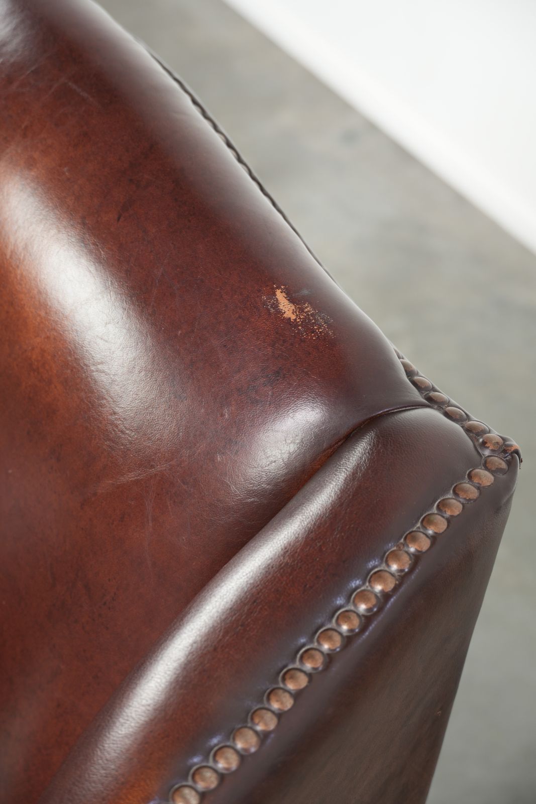 photo furniture Elegant Vintage Sheepskin Wing Armchair With A Timeless English Look, Finished With Decorative Nails.