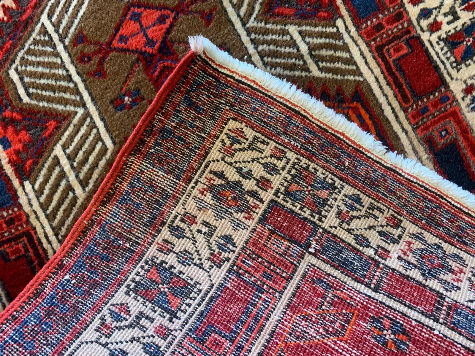 Handgemaakt loperkleed, geometrisch oosters motief, rood wollen tapijt photo vintage