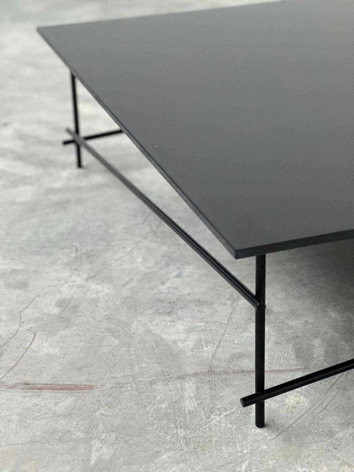 Minimalistische salontafel van zwart glas met industrieel metalen onderstel photo buy