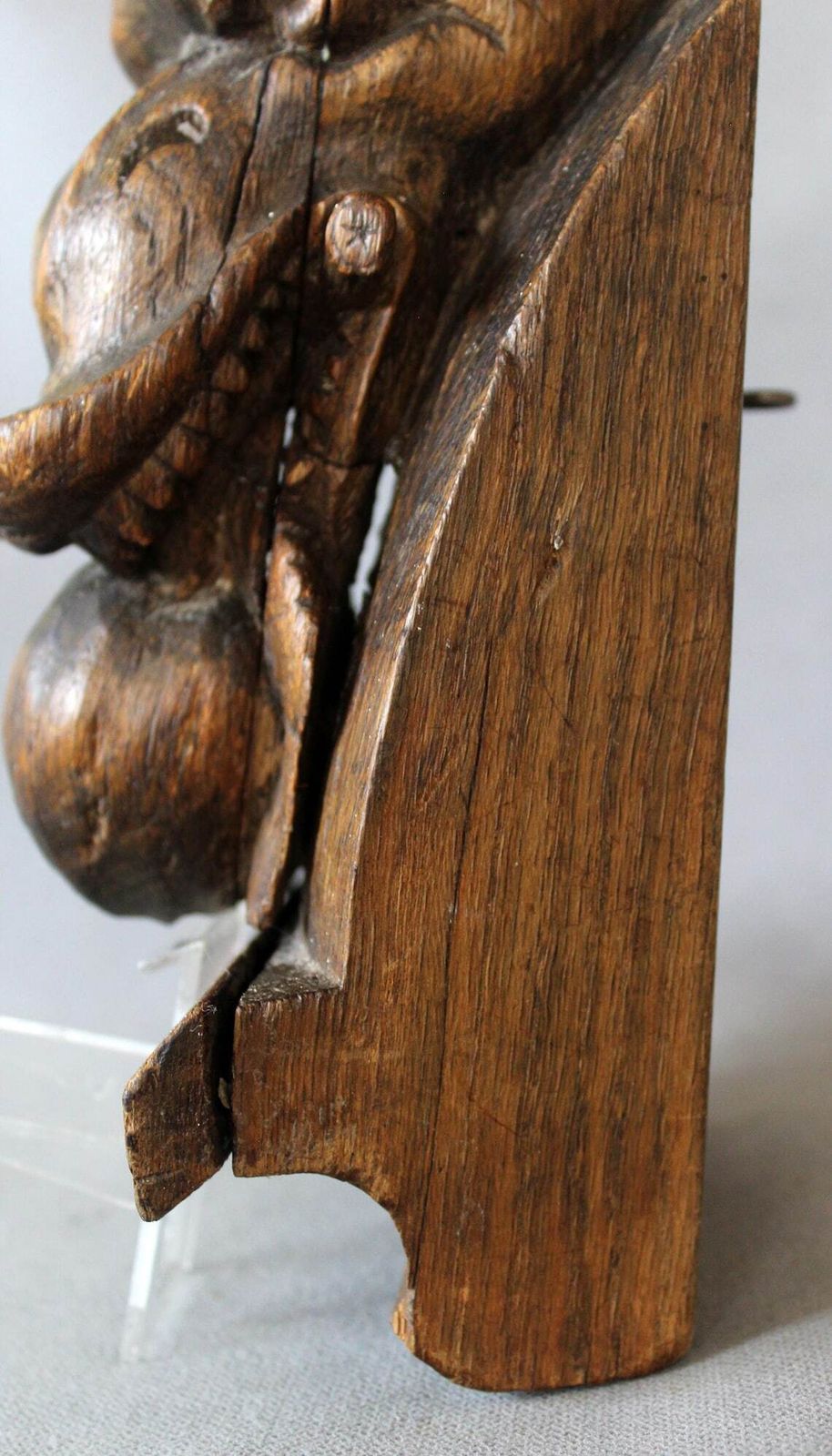 Groot antiek houten ornament in de vorm van een slangenkop met tanden die een appel of granaatappel eet, driedimensionaal, handgesneden, gotische architectuur photo vintage